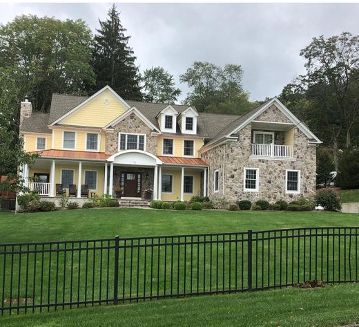 Yellow stone colonial with second-floor balcony — Storybook Homes NJ
