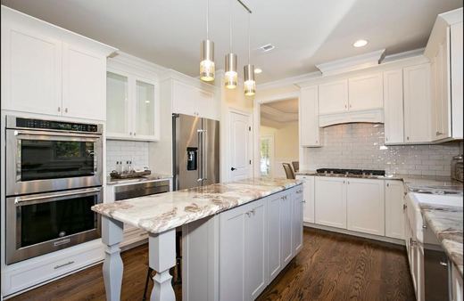 Kitchen with white cabinetry and professional gas range — Storybook Homes NJ