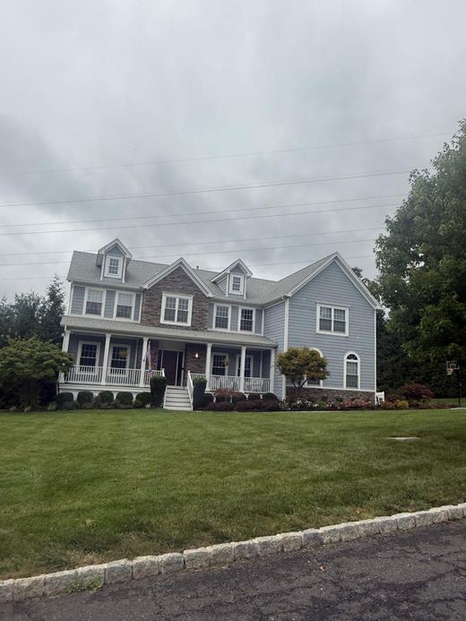 Blue-gray colonial with dormered roofline and covered porch — Storybook Homes NJ