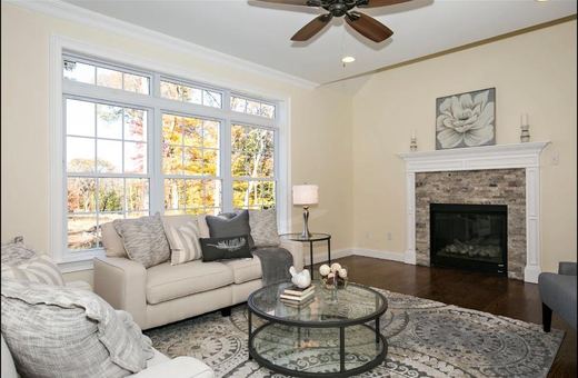 Living room with fireplace and tan sofas — Storybook Homes NJ