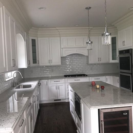Kitchen with white cabinetry and crystal pendant lighting — Storybook Homes NJ
