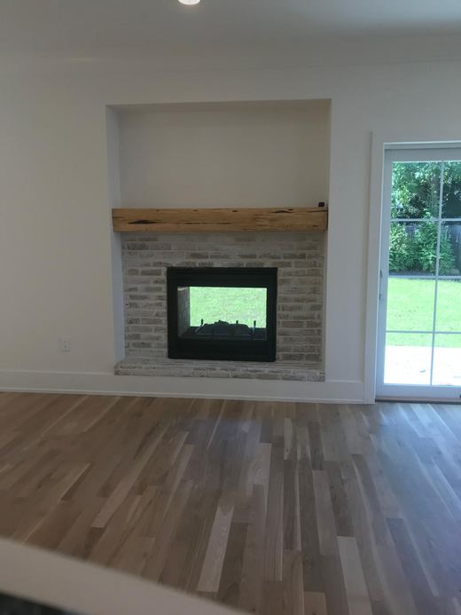 Living room with brick fireplace and glass doors to the yard — Storybook Homes NJ
