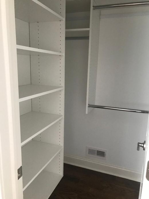 Walk-in closet with custom shelving and hanging storage — Storybook Homes NJ