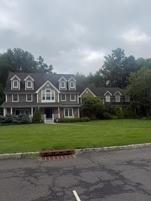 Gray colonial with red front door and wrought iron fencing — Storybook Homes NJ