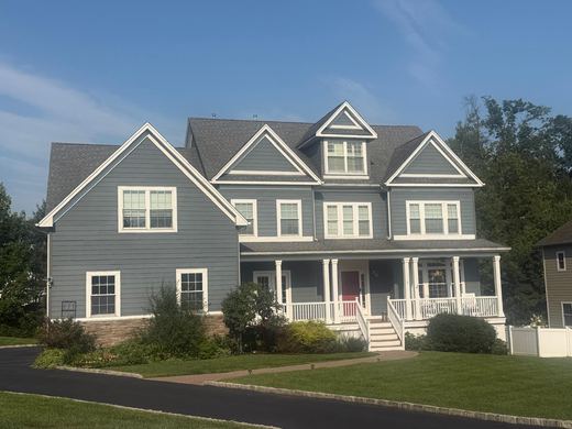Tan colonial with stone accents and manicured front lawn — Storybook Homes NJ